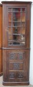 A 20th century oak standing corner cupboard,