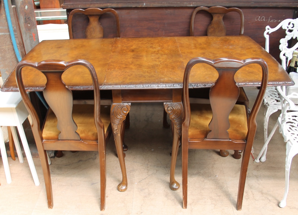 A 20th century walnut extending dining table and four chairs