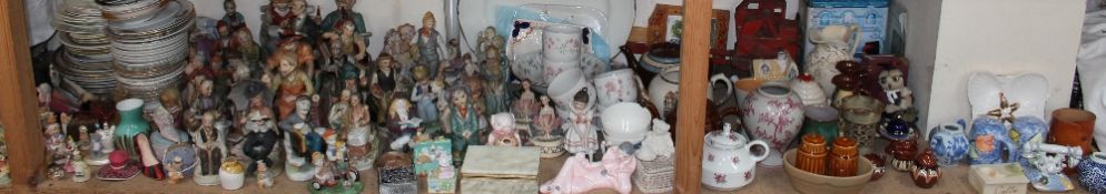 A collection of pottery figures together with a tin plate crane, pottery jugs, bookends, cruet sets,