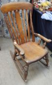 A 19th century rocking chair with a vase and slat back on ring turned legs