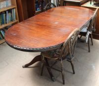 A reproduction mahogany extending dining table together with a set of four wheel back chairs