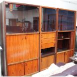 A modern wall unit in three sections with smoked glass doors,