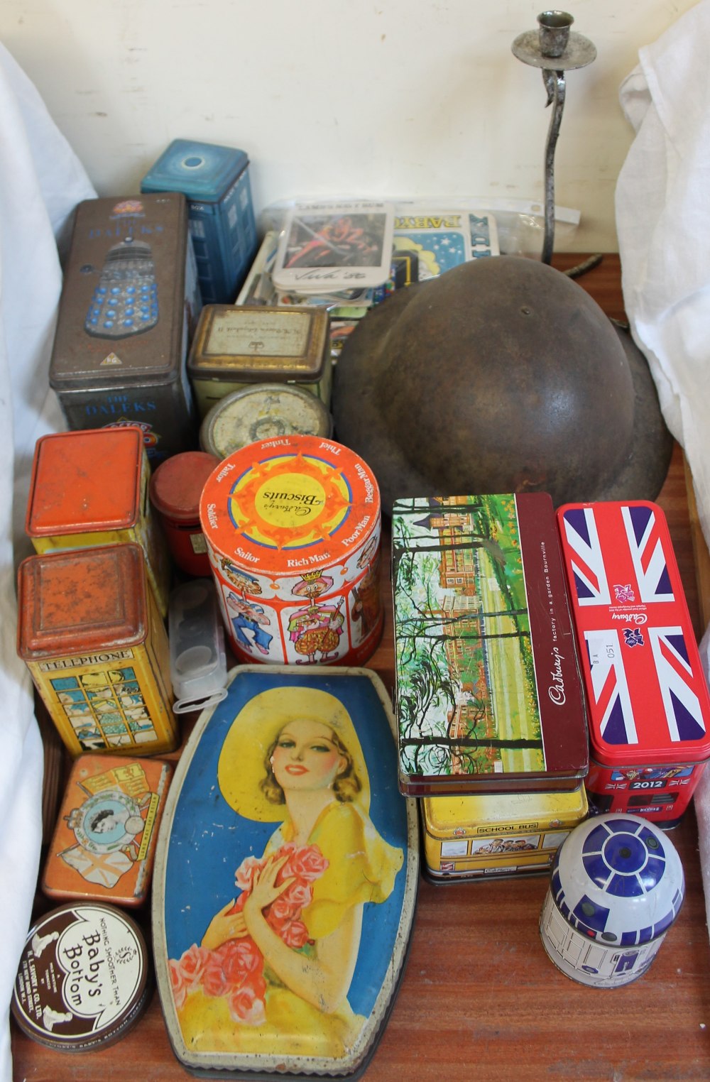 A tin helmet together with assorted tins etc