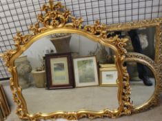 A large gilt decorated wall mirror together with three other gilt wall mirrors