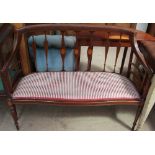 An Edwardian mahogany two-seater settee with vase shaped splats and pad seat
