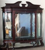 An Edwardian mahogany hanging display cabinet with a shaped cornice,