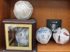 A Cardiff City Football Club signed football together with three other signed footballs and a