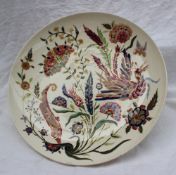 A Zsolnay Pecs pottery charger, decorated with a bird of paradise amongst flowers and leaves,