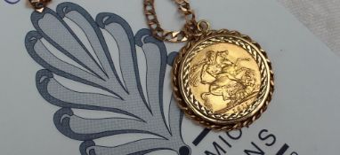 A George V gold sovereign, on a 9ct yellow gold chain and mount,