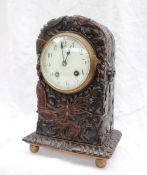A Chinese inspired mantle clock, carved with a dragon amongst clouds, on ball feet,