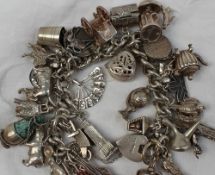 A silver charm bracelet, set with numerous charms including a crown, empire state building, lantern,