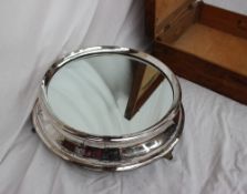 An electroplated wedding cake stand, of circular form with a mirrored plateau,