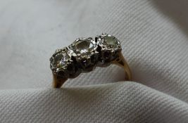 A three stone diamond ring set with round old cut diamonds, the central stone approximately 0.