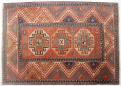 A red ground rug, with geometric medallions and flower heads,