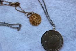 A George V gold sovereign dated 1912, with a suspension loop and a yellow metal chain,