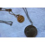 A George V gold sovereign dated 1912, with a suspension loop and a yellow metal chain,