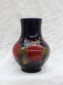 A Moorcroft pottery vase decorated in the Pomegranate pattern to a royal blue ground,