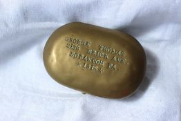 An American brass tobacco twist tin, of oval form, stamped "George Thomas, 2136 Brick Ave,