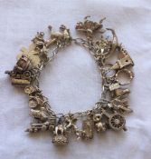 A silver charm bracelet set with numerous charms including a pony, car, shamrock, train, cupid,