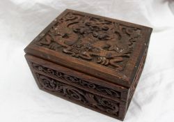 A carved oak Cigar box, carved with dragons and serpents, 21.