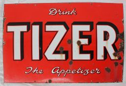 An enamel sign, with White and black edged text "Drink Tizer the appetizer" on a red ground,