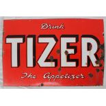 An enamel sign, with White and black edged text "Drink Tizer the appetizer" on a red ground,