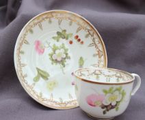 A Swansea porcelain teacup and saucer, painted with sprays of garden flowers and strawberries,