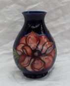 A Moorcroft baluster pottery vase, decorated in the anemone pattern to a royal blue ground,