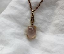 A 9ct yellow gold pendant set with a cabochon rose quartz on a plated chain