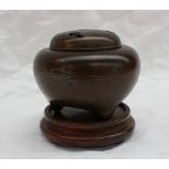 A Japanese bronze tripod koro, with a pierced domed cover,