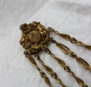 A gilt metal chatelaine, the top section cast with winged cherubs, flowers and scrolls,