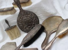 A George VI silver backed dressing table hand mirror together with a matching hair brush,