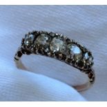 A five stone diamond ring set with graduating old cut diamonds to a white metal claw setting and