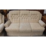 A cream floral three seater settee and matching arm chair