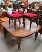 A Victorian mahogany dining table together with three Victorian balloon back dining chairs