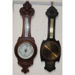 An oak cased aneroid barometer together with another oak cased barometer