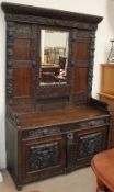 A 19th century oak low countries mirror back sideboard, carved with flowerheads and leaves,