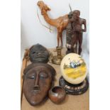 A painted ostrich egg on stand together with carved figures and mask and leather camel