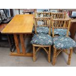 A pine kitchen table together with a set of four bamboo dining chairs