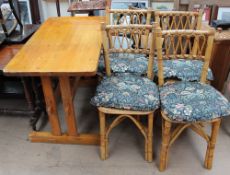 A pine kitchen table together with a set of four bamboo dining chairs