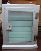 A silver painted table top display cabinet