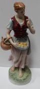 A Royal Dux figure of a maiden with a basket of fruit,