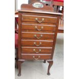 An early 20th century mahogany music cabinet with five drawers with drop fronts