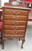 An early 20th century mahogany music cabinet with five drawers with drop fronts