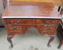A George II walnut low boy with a rectangular top above three drawers and an ogee shaped knee hole