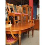 A modern satin walnut extending dining table together with six chairs,