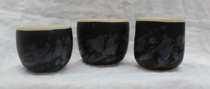 Studio pottery by Barbara Ineson - A set of three pottery vases with a black body and abstract