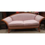 A Biedermeier style sofa with an arched back and out stretched arms with black painted stringing