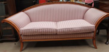 A Biedermeier style sofa with an arched back and out stretched arms with black painted stringing
