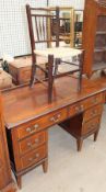 An Edwardian mahogany dressing table with an arrangement of six drawers on tapering legs together